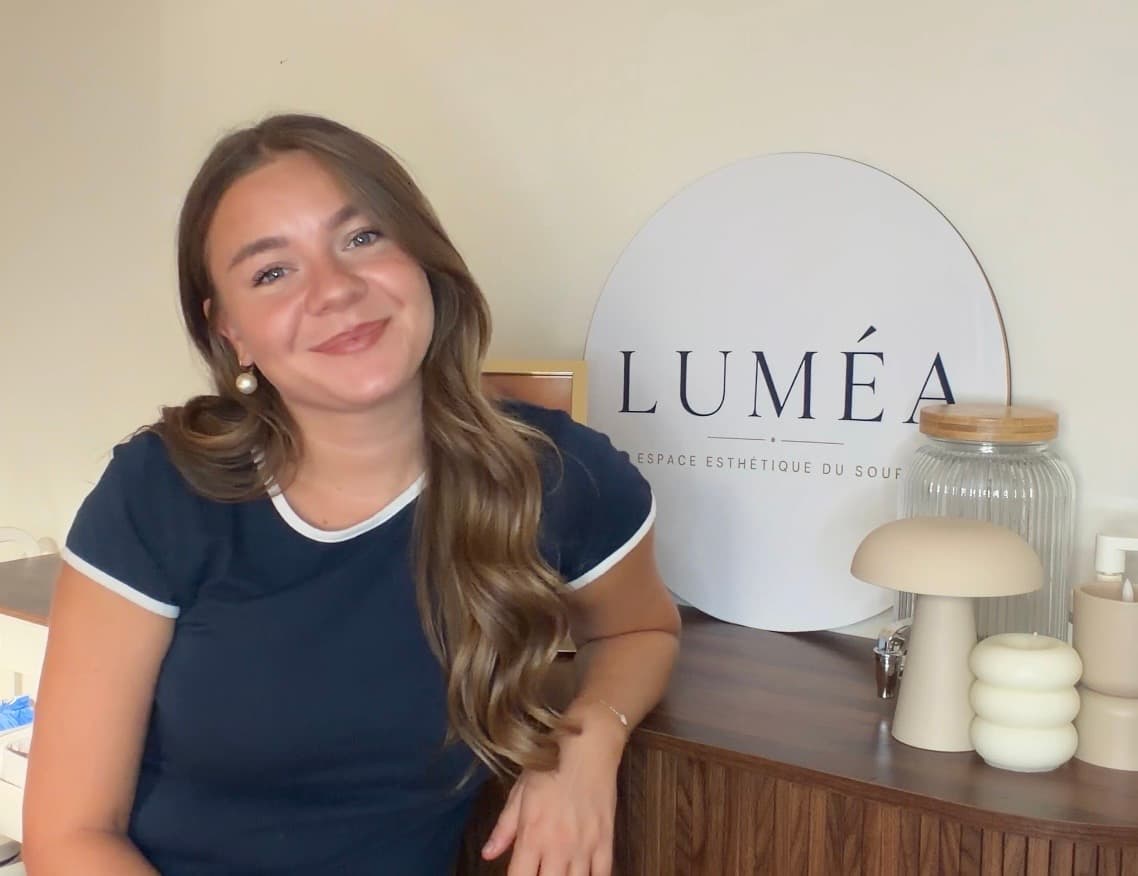 Tatiana, fondatrice de Luméa, devant l'enseigne de l'institut